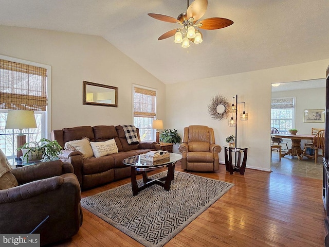 living room with hardwood / wood-style flooring, vaulted ceiling, and ceiling fan