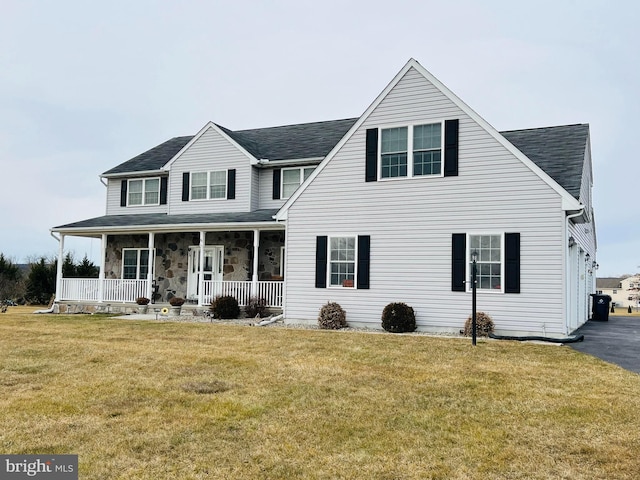 view of front of property featuring a garage, a front yard, and covered porch