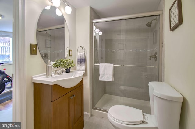 bathroom with an enclosed shower, vanity, and toilet