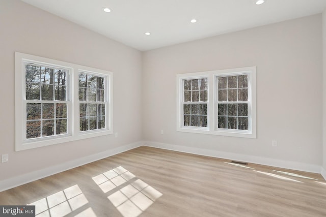 unfurnished room with light wood finished floors, baseboards, visible vents, and recessed lighting