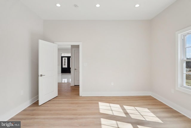 unfurnished room featuring light wood finished floors, recessed lighting, and baseboards