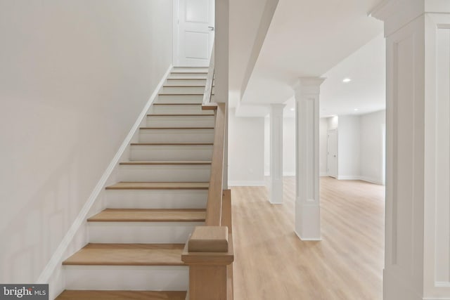 staircase with decorative columns, baseboards, wood finished floors, and recessed lighting