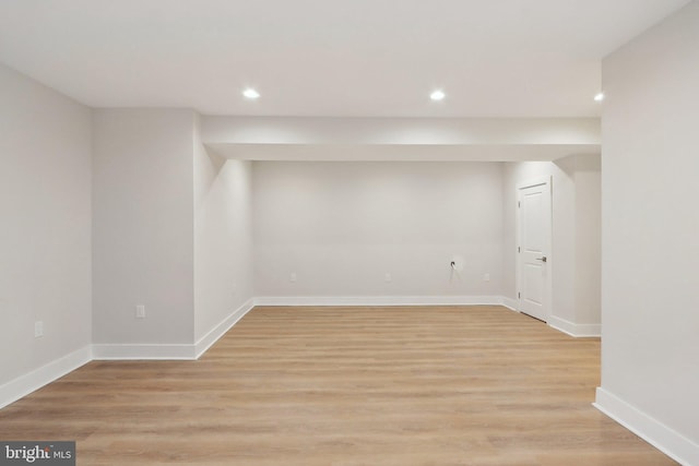 finished basement with light wood-style flooring, baseboards, and recessed lighting