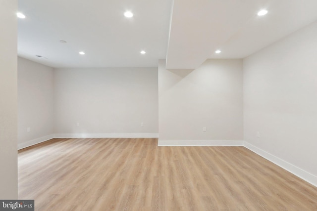 empty room featuring light wood-type flooring, baseboards, and recessed lighting