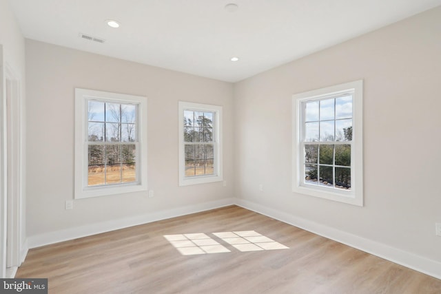 spare room featuring light wood-style floors, recessed lighting, and baseboards