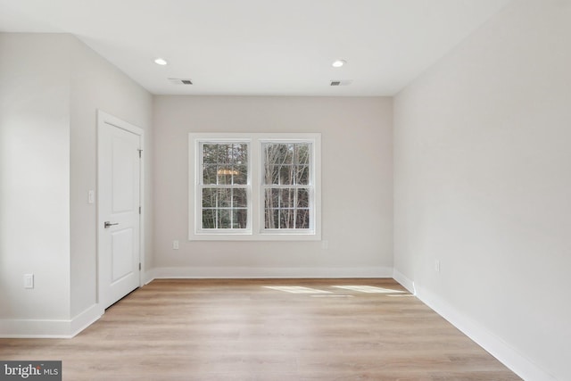 spare room featuring light wood-style flooring, recessed lighting, visible vents, and baseboards