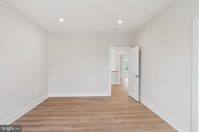 empty room featuring recessed lighting, light wood-style flooring, and baseboards