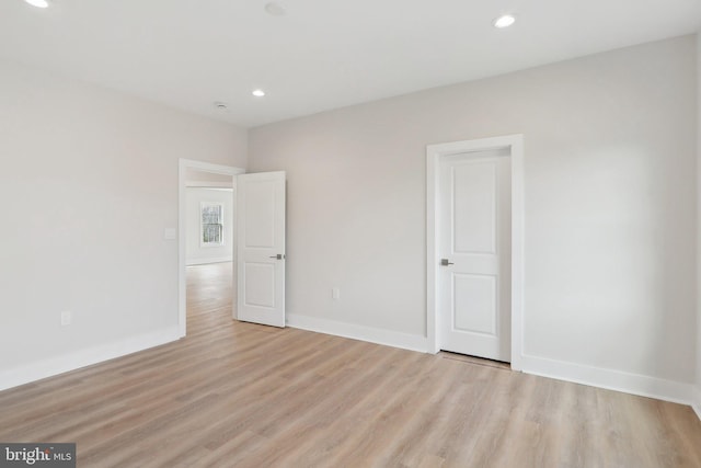 interior space featuring baseboards, light wood-type flooring, and recessed lighting