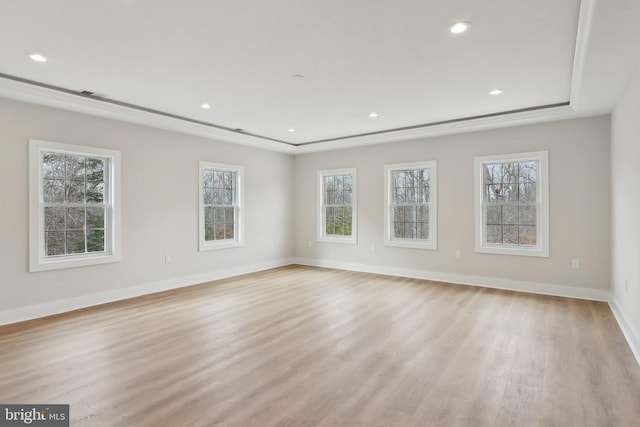 unfurnished room featuring recessed lighting, a raised ceiling, light wood-style flooring, and baseboards