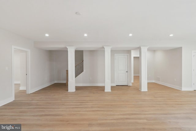 below grade area with light wood-type flooring, stairway, baseboards, and recessed lighting