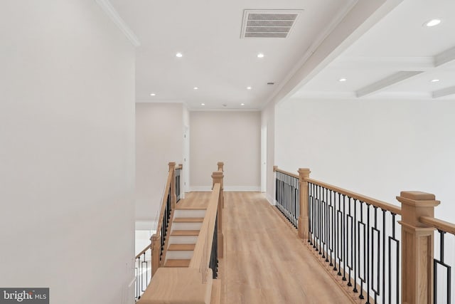 corridor with light wood finished floors, visible vents, crown molding, an upstairs landing, and recessed lighting