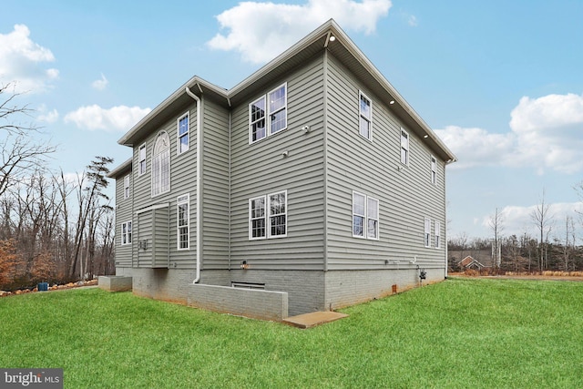 view of side of home with a yard