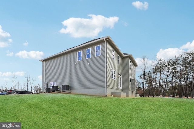 view of home's exterior featuring central air condition unit and a yard