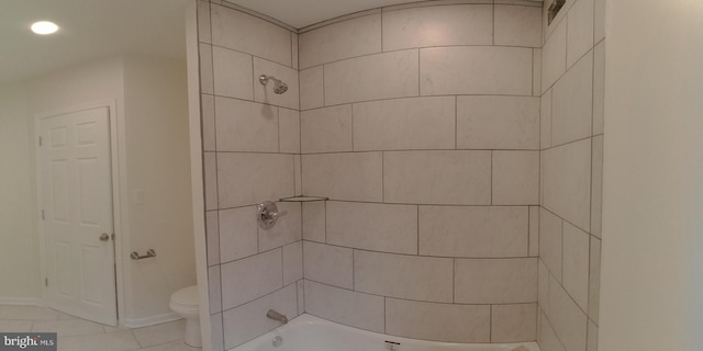 bathroom featuring tiled shower / bath combo and toilet