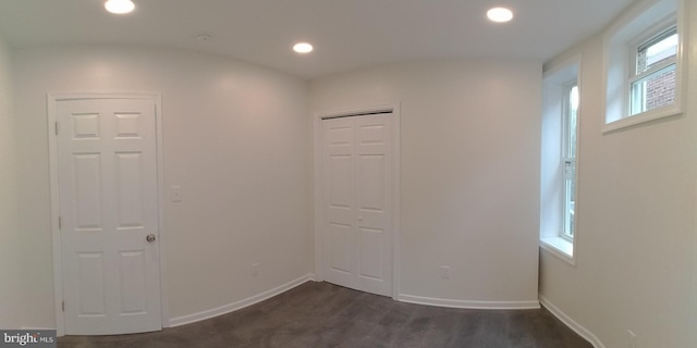 spare room featuring plenty of natural light and dark hardwood / wood-style floors