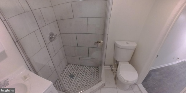 bathroom featuring a tile shower, tile patterned floors, and toilet