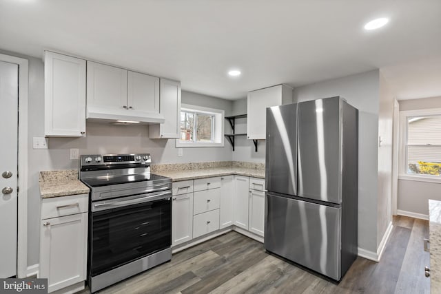 kitchen featuring white cabinetry, appliances with stainless steel finishes, light stone countertops, and dark wood-type flooring