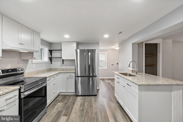 kitchen with sink, a center island with sink, stainless steel appliances, light stone countertops, and white cabinets