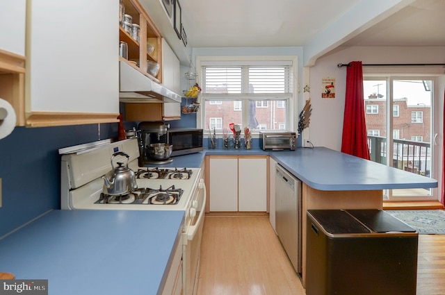 kitchen with white cabinetry, appliances with stainless steel finishes, kitchen peninsula, and light wood-type flooring