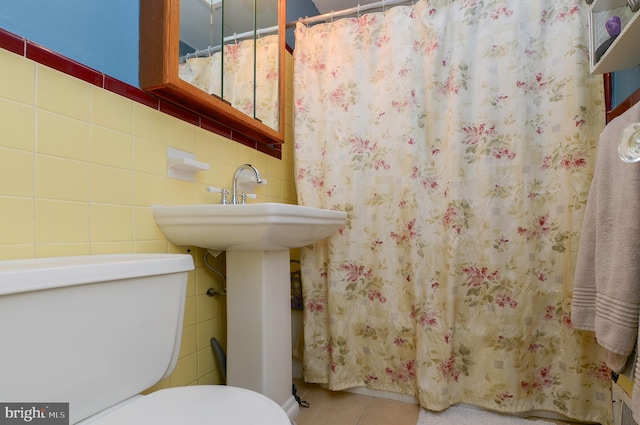 bathroom with tile walls, tile patterned floors, and toilet