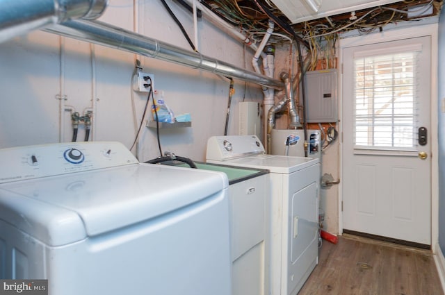 clothes washing area with hardwood / wood-style floors, electric panel, and washer and dryer