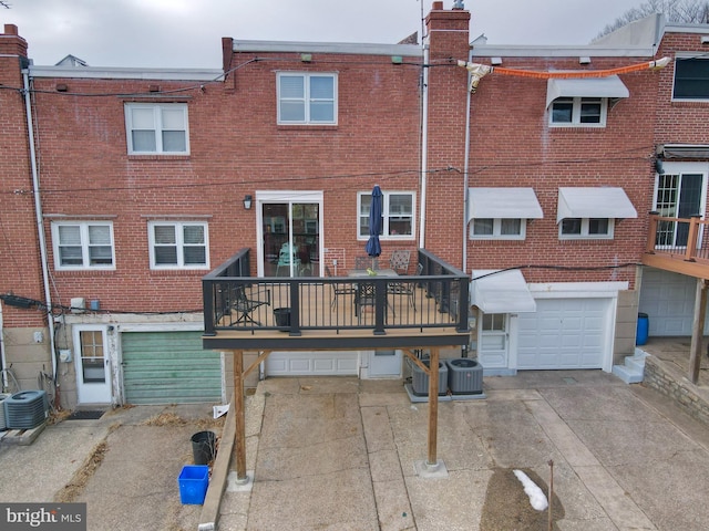 back of property featuring a garage and central AC