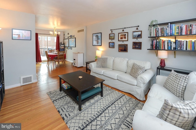 living room with an inviting chandelier and hardwood / wood-style floors