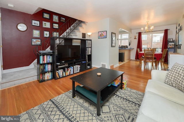 living room featuring an inviting chandelier and light wood-type flooring