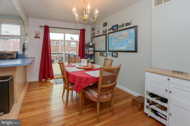 dining space with a notable chandelier and light wood-type flooring