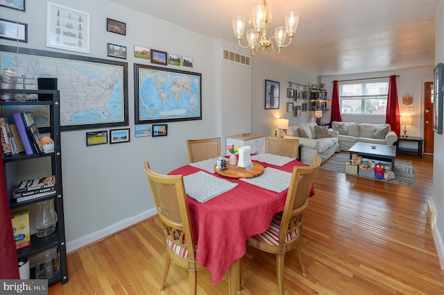 dining area with a chandelier and light hardwood / wood-style floors