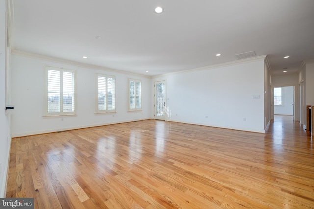 empty room with ornamental molding and light hardwood / wood-style floors