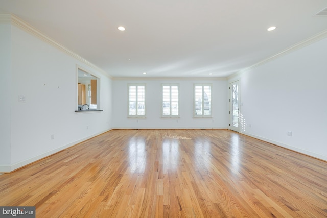 empty room featuring crown molding and light wood-type flooring