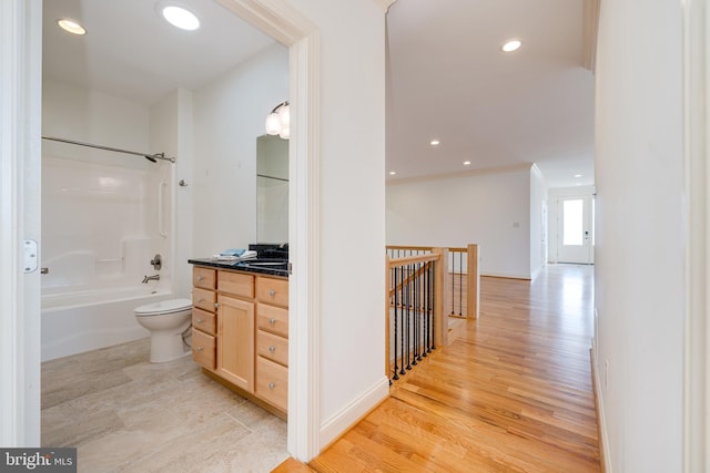 full bathroom with hardwood / wood-style floors, vanity, bathing tub / shower combination, and toilet