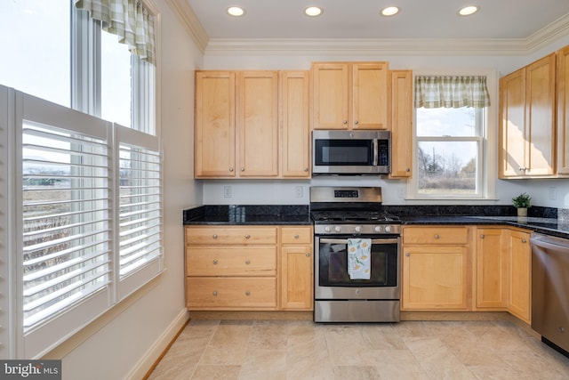 kitchen with appliances with stainless steel finishes, light brown cabinets, and dark stone countertops