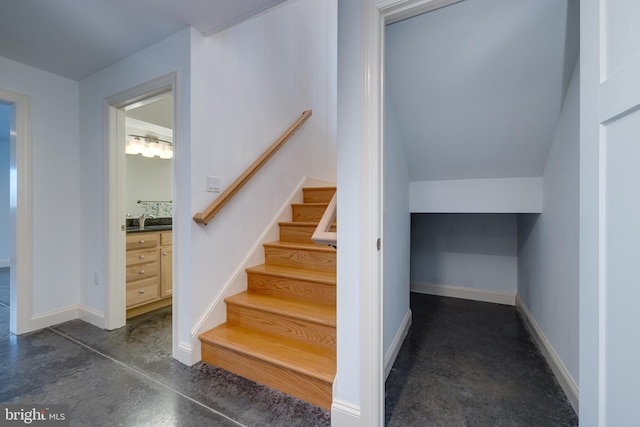 stairway featuring concrete flooring and sink