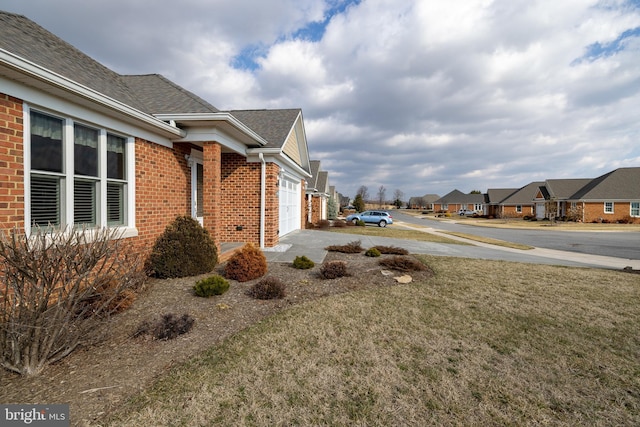 view of side of property with a yard and a garage