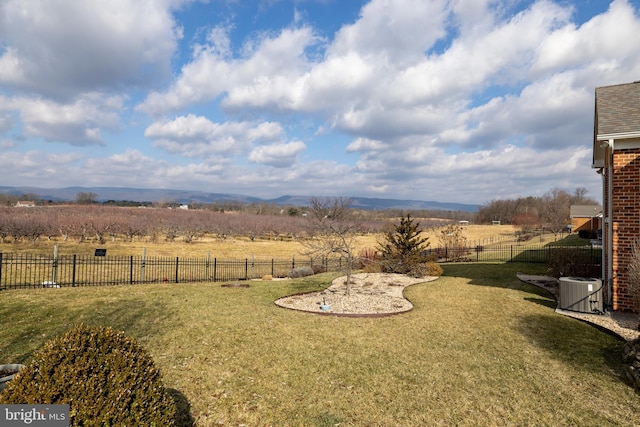 view of yard with central air condition unit and a rural view