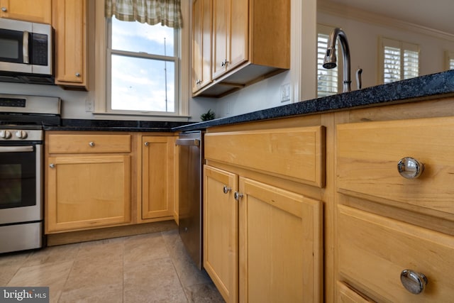 kitchen featuring dark stone countertops, crown molding, light tile patterned flooring, and appliances with stainless steel finishes