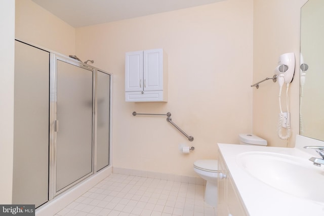 bathroom featuring vanity, a shower with shower door, tile patterned floors, and toilet