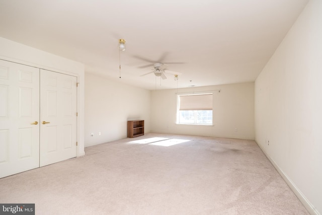 interior space with light carpet, a closet, and ceiling fan