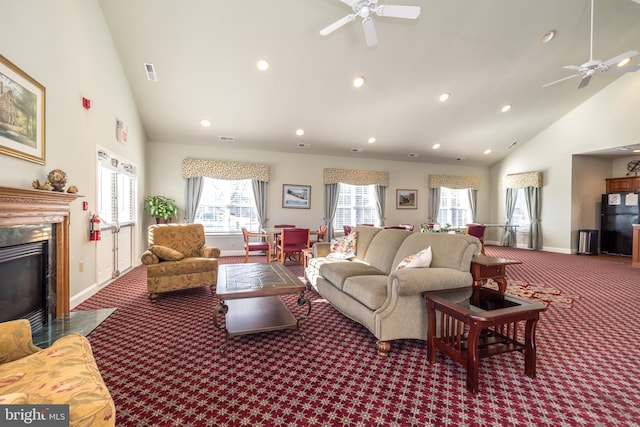 living room with ceiling fan, a premium fireplace, carpet flooring, and high vaulted ceiling