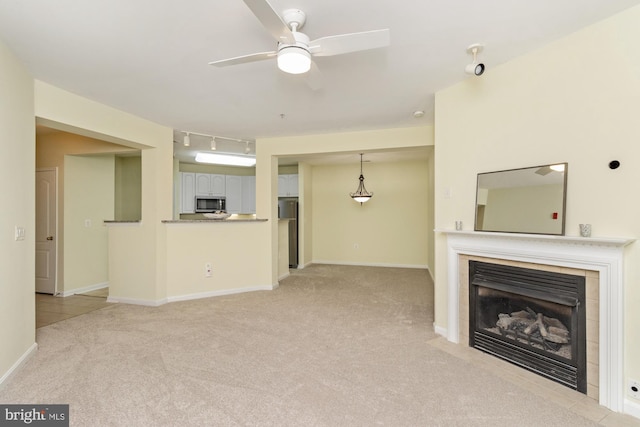 400 Symphony Cir Unit 136E, Cockeysville, MD 21030 - unfurnished living room with light colored carpet, a ceiling fan, a tiled fireplace, and baseboards