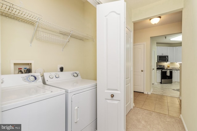 400 Symphony Cir Unit 136E, Cockeysville, MD 21030 - laundry room with washer and dryer, light tile patterned floors, and baseboards