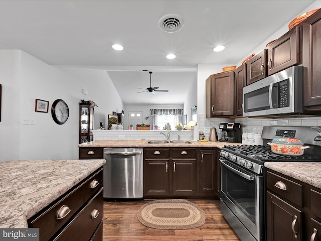 kitchen featuring tasteful backsplash, appliances with stainless steel finishes, sink, and dark brown cabinets