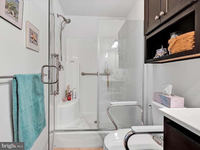 bathroom with vanity, toilet, and a shower with door