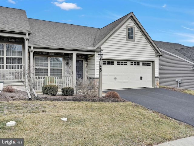 view of front of house with a garage, a porch, and a front yard