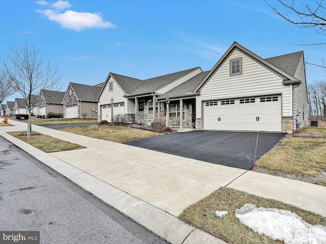 view of front of home with a garage, covered porch, and a front yard