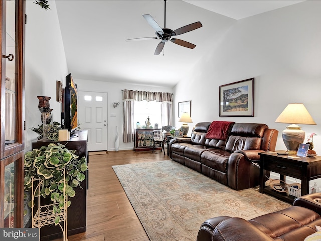 living room with ceiling fan, high vaulted ceiling, and light hardwood / wood-style flooring