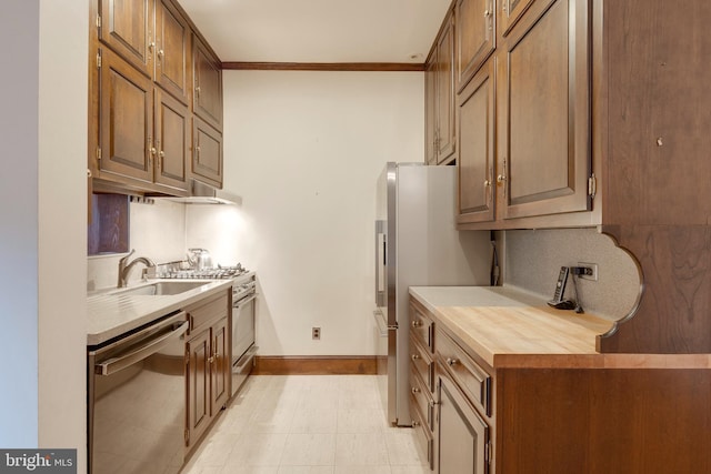 kitchen featuring ornamental molding, appliances with stainless steel finishes, sink, and decorative backsplash