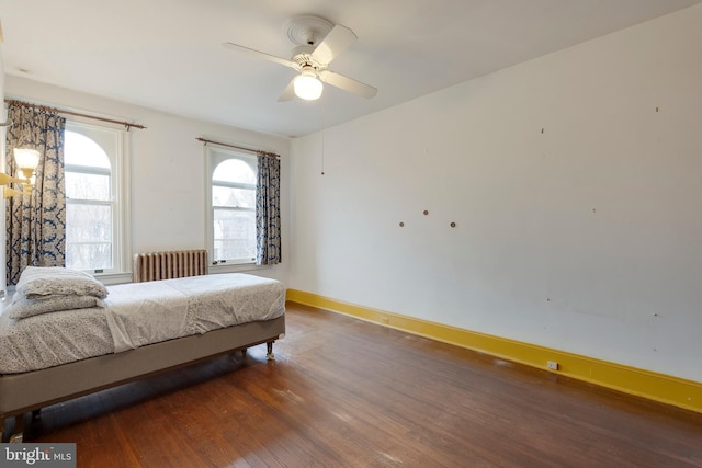 bedroom featuring ceiling fan, dark hardwood / wood-style flooring, and radiator